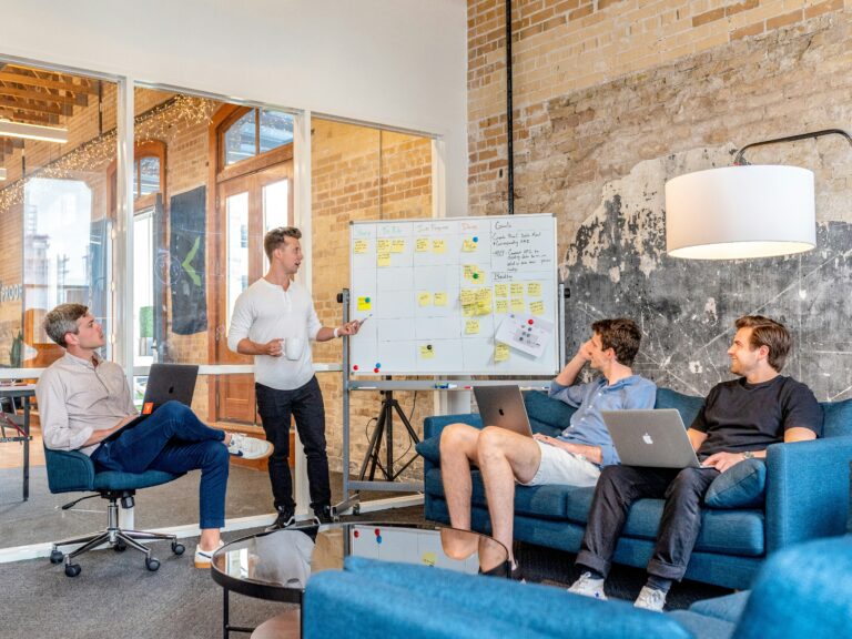 Salle de réunion avec quatre collaborateurs discutant