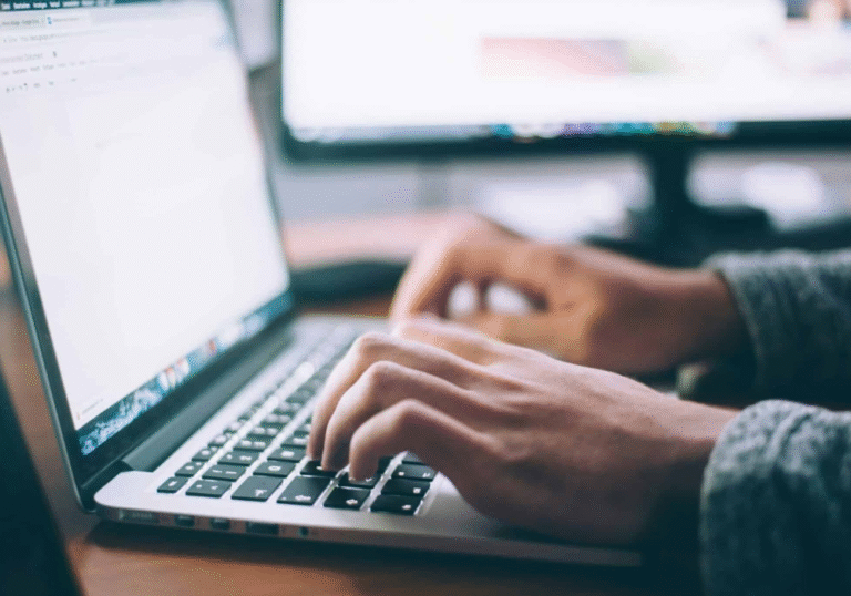 Une personne concentrée en train de taper sur son clavier, illustrant la productivité au bureau.
