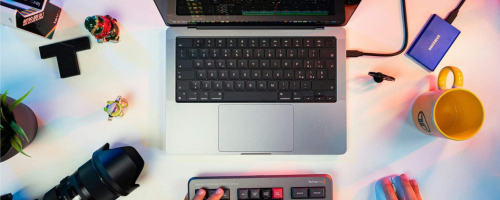 Un professionnel du montage vidéo travaille sur son ordinateur avec un appareil photo professionnel à ses côtés, illustrant la polyvalence et l'expertise dans la production multimédia.Photo de TheRegisti sur Unsplash