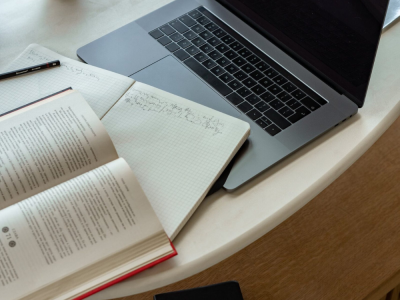 Ordinateur sur un bureau à côté d'un livre de notions