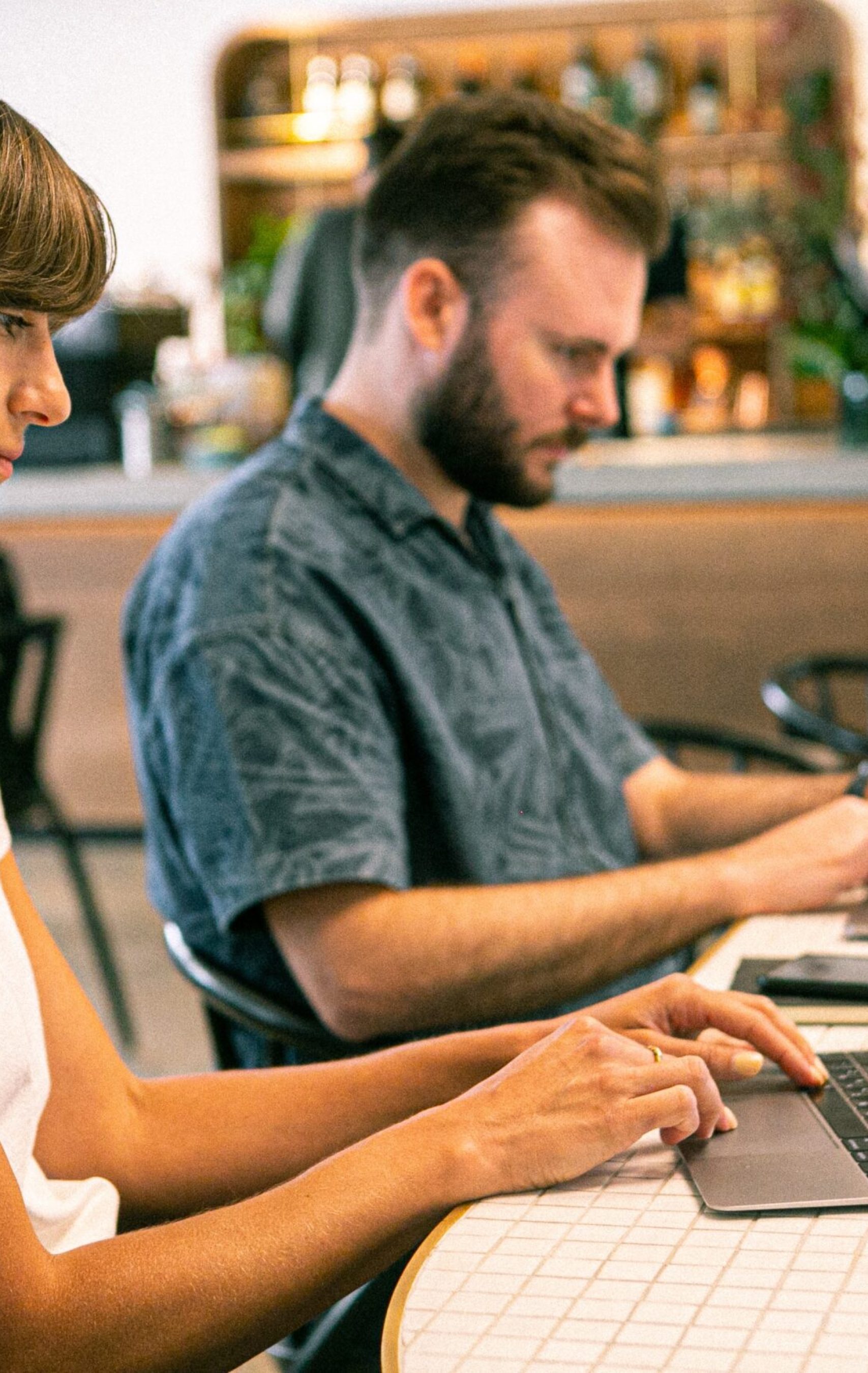 Deux personnes travaillant sur leurs ordinateurs pour avancer sur des projets