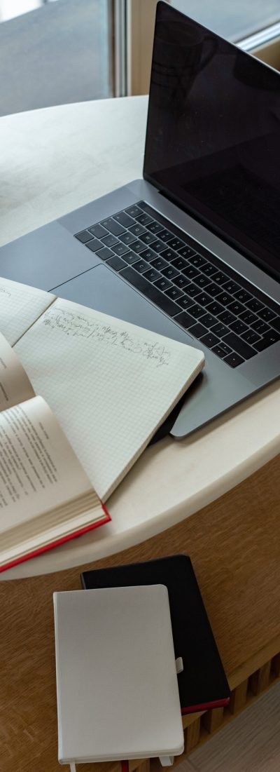 Ordinateur sur un bureau à côté d'un livre de notions