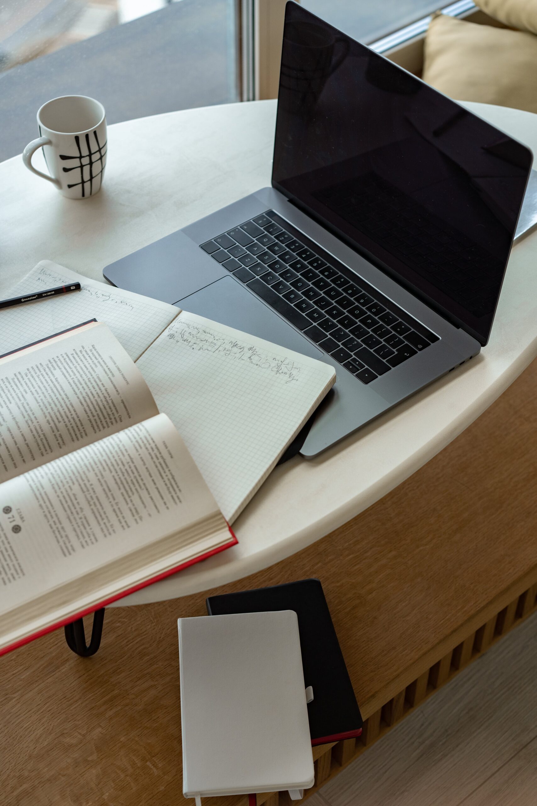 Ordinateur sur un bureau à côté d'un livre de notions